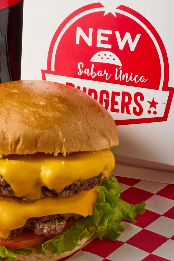 Hamburguesa doble con queso frente al logo New Burgers